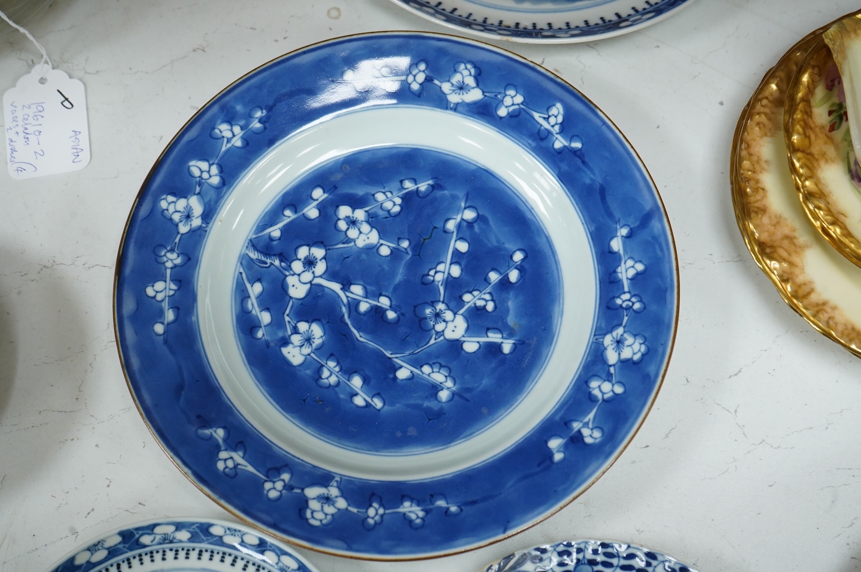 A 19th century Chinese blue landscape plate another smaller, prunus plate, another with restored rim, largest 22.5cm diameter.